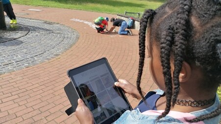 Ein Mädchen nutzt das Tablet und die App #stadtsache um eine Idee für Berg Fidel festzuhalten. 